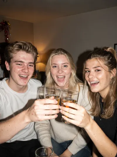 Drie vrienden proosten op een huisfeest